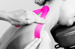 Fisiotheraphist/doctor applying cervical kinesiotape in silhouette studio on white background.