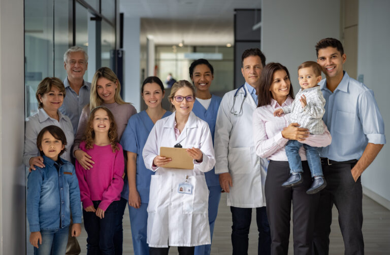 Happy group of doctors and patients at the hospital
