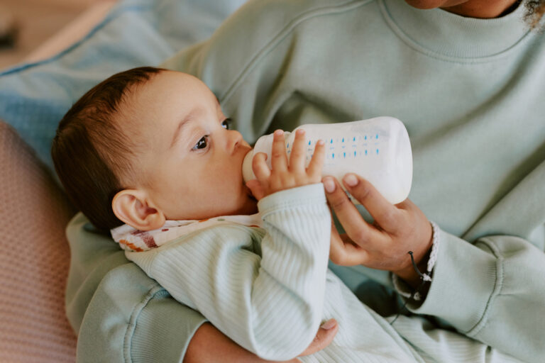 Baby Eating Formula in Mothers Arms