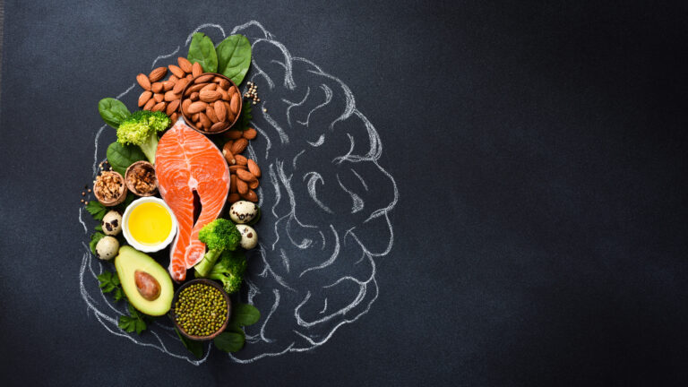 A picture of the brain drawn in chalk with various food products: fish, meat, nuts, vegetables and greens. Healthy food